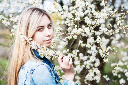 Beautiful girl in the  spring cherry blossoming garden