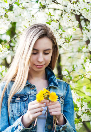 Beautiful girl in the  spring cherry blossoming garden