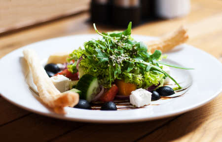 greek salad with fresh vegetables, feta cheese and black olivesの写真素材