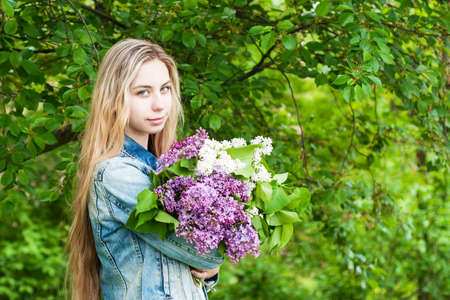 Girl with a bouquet of lilac flowersの写真素材