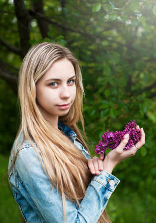 Girl with a bouquet of lilac flowersの写真素材