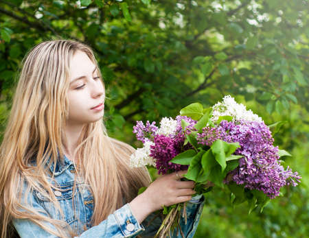 Girl with a bouquet of lilac flowersの写真素材