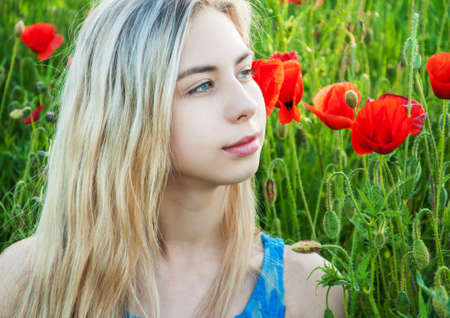 Beautiful young girl in the poppy fieldの写真素材