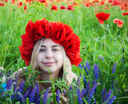 Beautiful young girl in the poppy fieldの写真素材