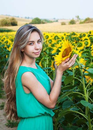 Beautiful  girl on the field of sunflowersの写真素材