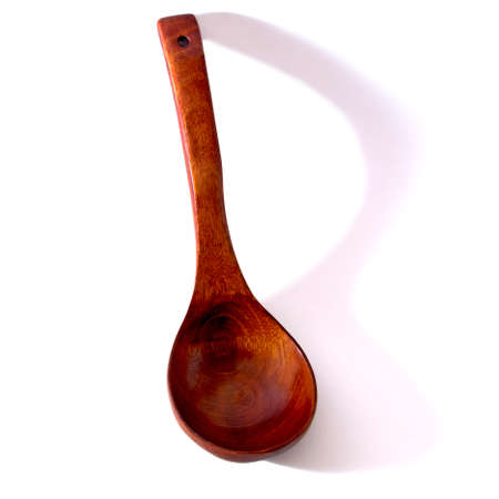 Wooden brown spoon on a white background it is isolated. Soft light.の写真素材