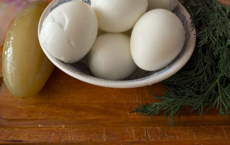 Boiled eggs on a plate, salted cucumber and green dill.の写真素材