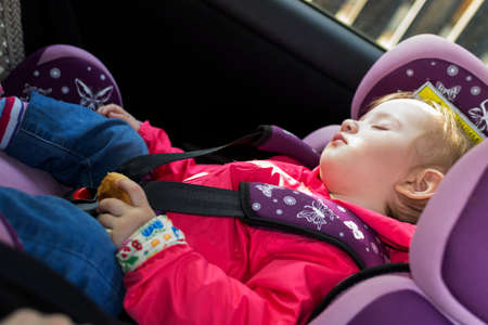 Sleeping child in an automobile armchairの写真素材