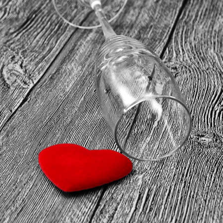 The concept of harm of alcohol to health and family. Black and white background, red heart and empty wine glass.の写真素材