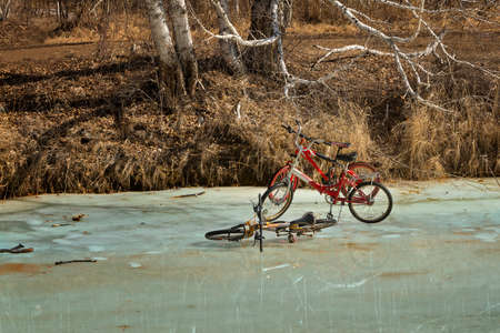 Bicycles on the river in early spring, when the ice begins to melt.の写真素材