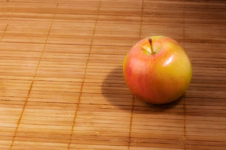 Ripe apple on wooden napkin, side view. The concept of vegetarianism, healthy food.の写真素材