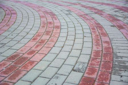 Stone pavement in perspective. Stone pavement texture. Granite cobblestoned pavement background. Abstract background of a cobblestone pavementの写真素材