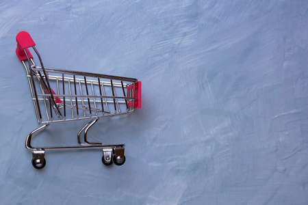 Baskets shopping cart or shopping trolley on concrete surface background using as online shopping, e-commerce, supermarket consumer purchase concept.の写真素材