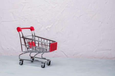 Baskets shopping cart or shopping trolley on concrete surface background using as online shopping, e-commerce, supermarket consumer purchase concept. Selective focus.の写真素材