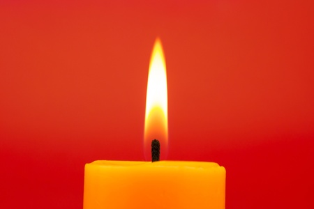 Candle Burning On Red Backgroundの写真素材