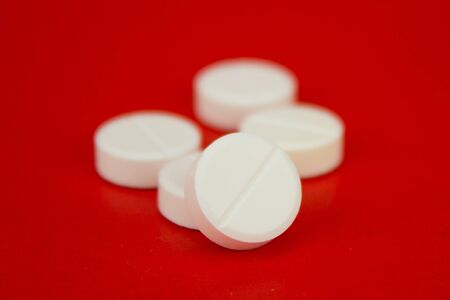 White Pills On Red Background