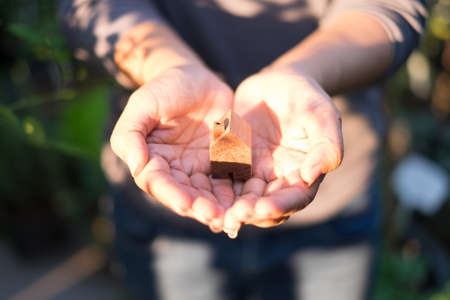 wooden model house in handsの写真素材