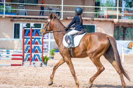 little girl is riding a horseの写真素材
