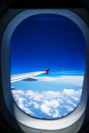 View from airplane window with blue sky and white cloudsの写真素材