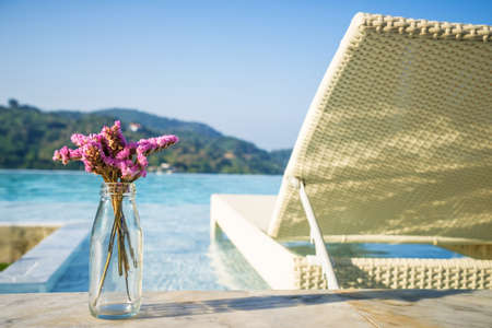 Bouquet of violet lilac in a vase and pool bedの写真素材