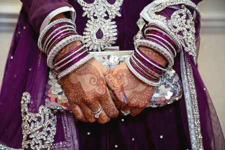 Bride wearing purple holding clutch bag