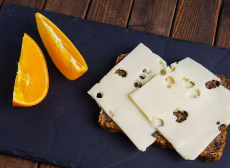 wholemeal rye bread with cheese and orange sliceの写真素材