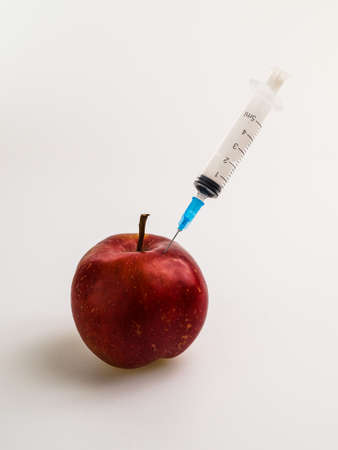 apple with syringe, Whole and on white backgroundの写真素材