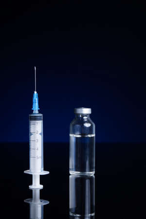 Syringe and medical vial, with blue backgroundの写真素材