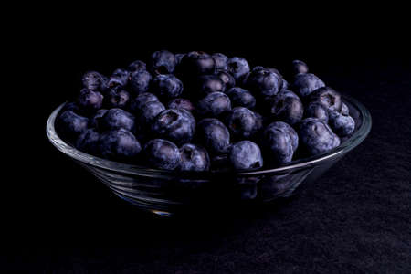 Blueberry in a glass bowl isolated on Blackの写真素材