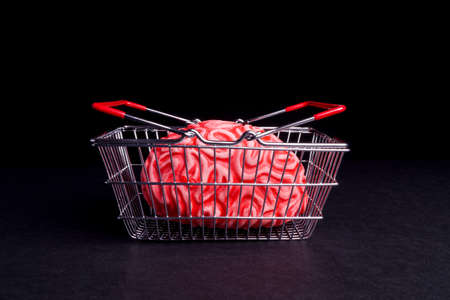 Think before you Bye. Brain and shoppingcart isolated on Blackの写真素材