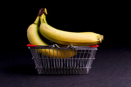 Basket of Ripe Organic Bananas isolated on Blackの写真素材