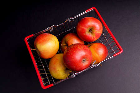 Basket of ripe red apples isolated on Blackの写真素材