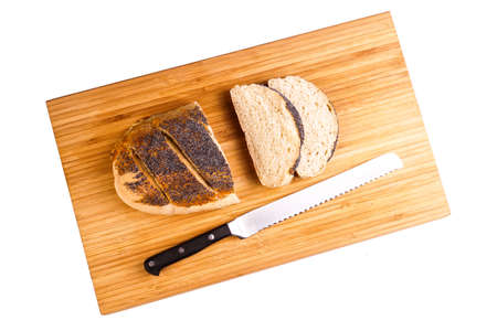 Homemade Organic Bread loaf lying on a wood Board, sliced with the knife, ready for making a...