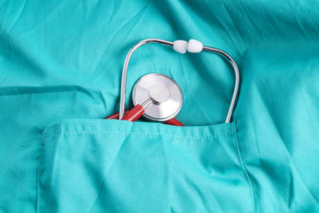 Surgeon with stethoscope in pocket, isolated on green background with stethoscope in pocketの写真素材