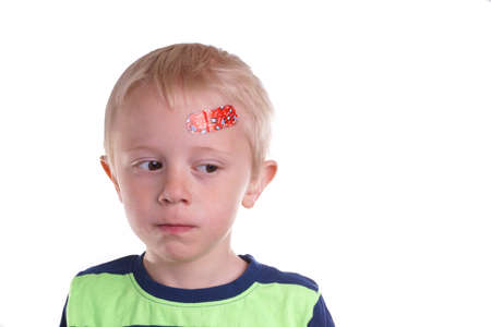 Child gets injury on the forehead has a plaster on the wound so it can healの写真素材