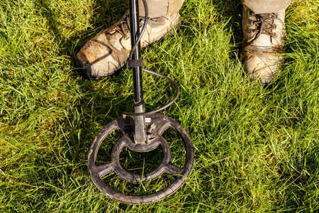 Metal Detector. Man with metal detector  he uses it to find archaeological treasures in the grassの写真素材
