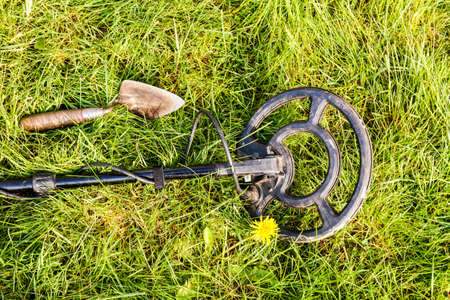Metal Detector. Beside the detector lies a trowel ready to dig the treasure out of the groundの写真素材