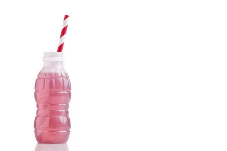 bottle of red lemonade or juice and striped straws, isolated on white with copy spaceの写真素材
