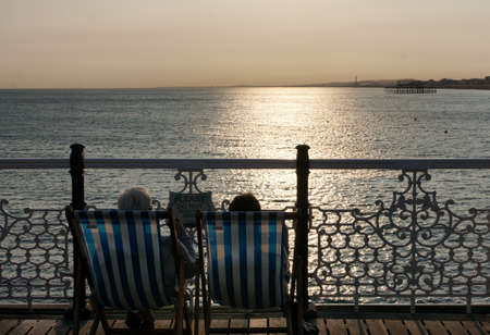 sunset overlooking the water sitting in deckchairs