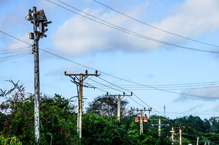power poles with many wires against the blue sky