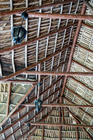 Roof made of dry palm leaves, back side with wooden beams and lanterns