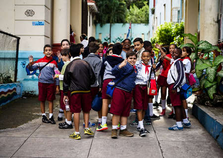Havana, Cuba - January 6, 2016: Typical scene of one of streets in the center of La Havana - A group of schoolchildren standing in front of their school, waiting for the teacher allowed them to get into teachingのeditorial素材