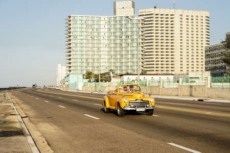 Havana, Cuba - January 7, 2016: Typical scene by the Malecon in La Havana - Yellow vintage american...