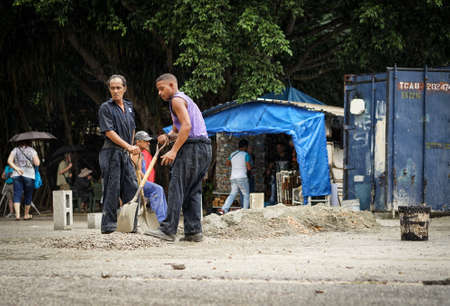 Havana, Cuba - January 8, 2016: Workmen are working with shovels. They make concrete manually on the groundのeditorial素材