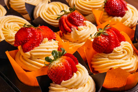 Tray of Strawberry cupcakes with frosting and fresh berryの写真素材