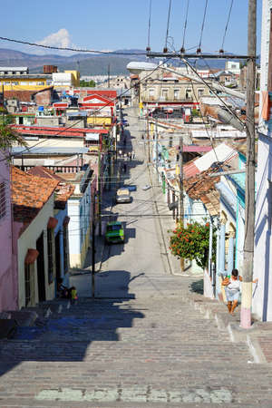 Santiago de Cuba, Cuba - January 10, 2016: Typical scene of one of streets in the center of Santiago de cuba - Colorful architecture, people walking around. Santiago is the 2nd largest city in Cubaのeditorial素材