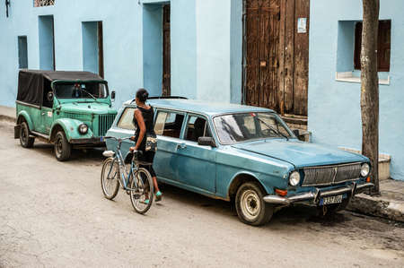Santiago de Cuba, Cuba - January 13, 2016: Typical scene of one of streets in the center of Santiago de cuba - Colorful architecture, people walking around. Santiago is the 2nd largest city in Cubaのeditorial素材