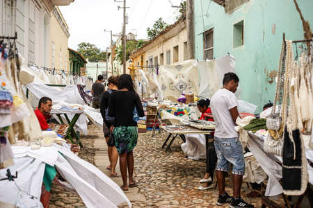 Trinidad, Cuba - January 14, 2016: Typical scene of one of streets in the center of Trinidad, Cuba - colonial architecture, people walking around, street market selling souvenirs to touristsのeditorial素材