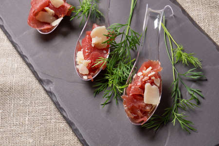 Appetizer with meat, Carpaccio and parmesan served on a Spoonの写真素材
