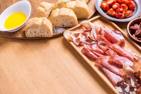 Tapas food, served in small bowls cold meat, goat cheese. A meal for sharing